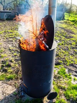 Tree branches burn in barrel for burning garbage Stock-Fotos