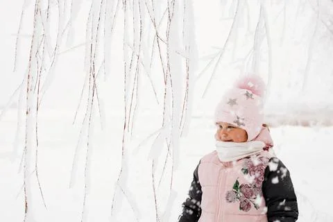 Tree branches covered with snow with blissful girl with rosy cheeks looking away Stock Photos