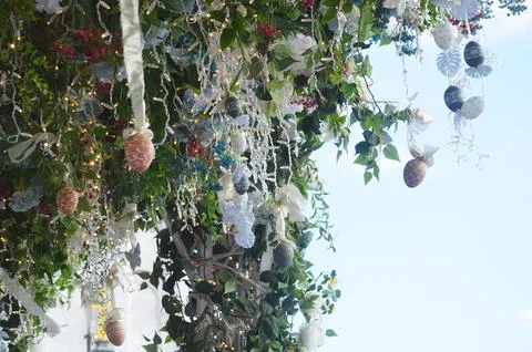 Tree branches decorated with painted Easter eggs, flowers, ribbons, lights. F Stock Photos