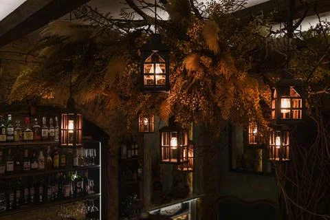 Tree branches with hanging old lanterns in restaurant bar Stock Photos