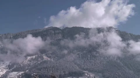 Tree-covered snowy mountain top with clouds Video stock 10787547
