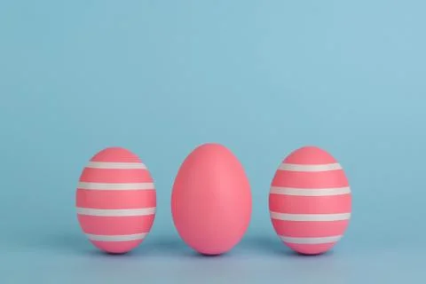 Tree Easter decorated pink eggs in a row. Blue background. Copy space. Foto stock