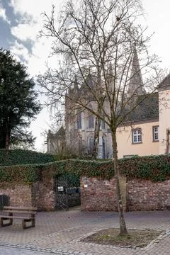 A tree is in front of a building with a gate in Xanten Germany Stock Photos