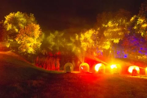 The tree is highlighted in red and orange in the dark. art installation Stock Photos