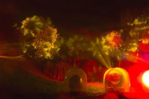 The tree is highlighted in red and orange in the dark. art installation Stock Photos