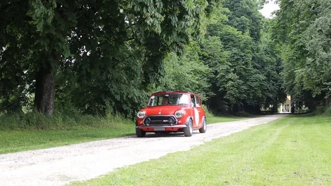 Tree-lined avenue with old red car Stock Footage 89786287
