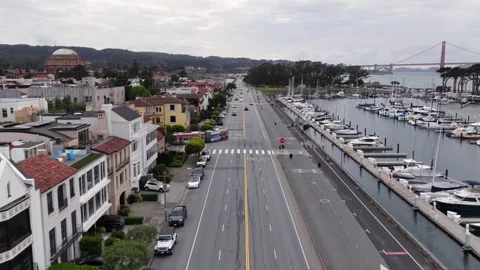Tree-lined boulevard runs parallel to marina filled with sailboats, Golden Gate Stock Footage 337746439