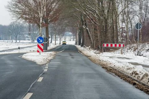 Tree lined road with yellow van approaching through a winter corridor Stock Photos
