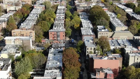 Tree-lined rowhouse blocks running through Bedford-Stuyvesant Stock Footage 119243962