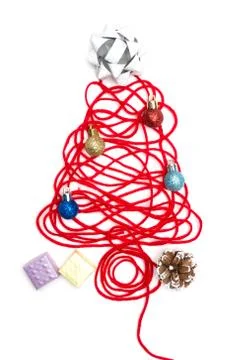 A tree made of red thread and ribbon, ball, small box, pine cone on white bac Stock Photos