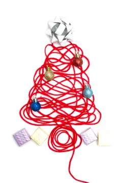 A tree made of red thread and ribbon, ball, small box on white background Foto stock