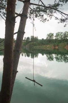 Tree with a man-made rope swing by the river Stock Photos