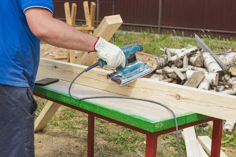 Tree. natural wood in the shape of a rectangle. work piece. a man uses a tool Stock Photos