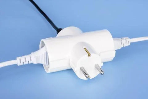 Tree plugs socketed into white electric splitter on a blue background. Stock Photos