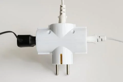 Tree plugs socketed into white electric splitter on a white background. Stock Photos