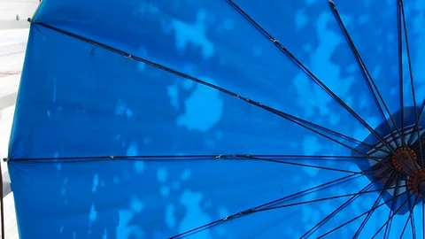 Tree shade through blue canvas umbrella Stock Footage 80322569