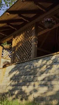 Tree shadows dancing on a rustic stone wall and a wooden terrace Foto stock