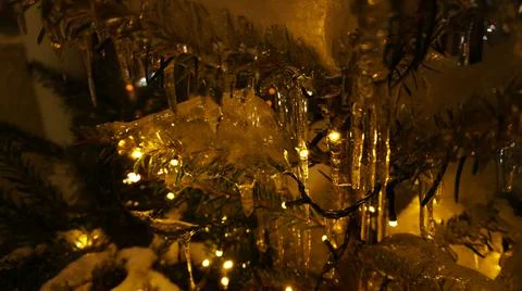 The tree of a small Christmas tree in icicles is illuminated with garlands near  Foto stock