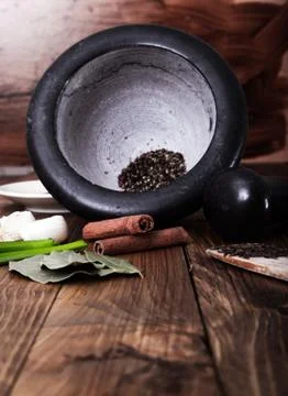 Tree spoons with spices and a bundle of herbs, mortar and pestle Foto stock
