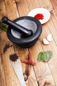 Tree spoons with spices and a bundle of herbs, mortar and pestle Stock Photos