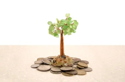 Tree standing on coins from different countries Stock Photos