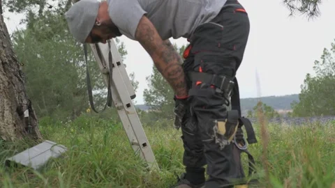 Tree surgeon putting on climbing gear Stock Footage 301860040