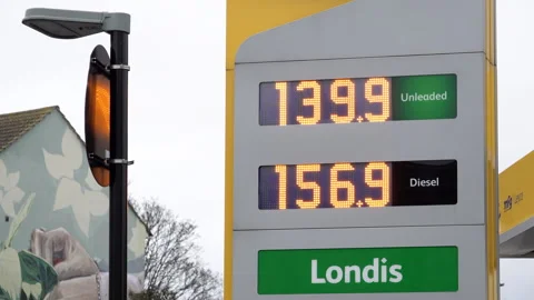A Tree Sways In The Wind As A Jet Petrol Station Sign Displays Current Fuel Stock Footage 332713165