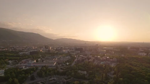 Tree tops and building roofs against sunset sky in Sofia, Bulgaria Stock Footage 195981822