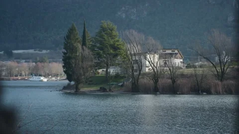 Tree trunk reveal mountain lake house panning handheld Stock Footage 341339283