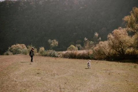 Tree years old boy playing with his small husky dog in the middle of nature Stock Photos