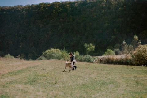 Tree years old boy playing with his small husky dog in the middle of nature Stock Photos
