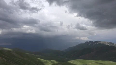Treeless mountain valleys timelapse with sun rays breaking through storm clouds Stock Footage 333775022