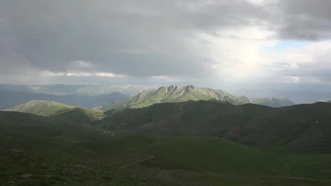 Treeless mountain valleys timelapse with sun rays breaking through storm clouds Stock Footage 333775278