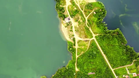 Trees, agricultural fields and roads surrounding a lake in countryside near town Stock Footage 269164542