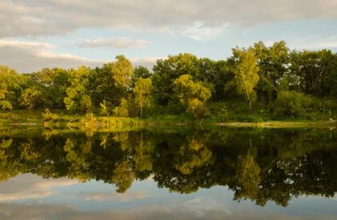 Trees and clouds reflected in the water Stock Photos