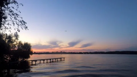Trees and pier on the lake in the sunset Stock Footage 82371499