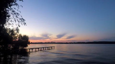 Trees and pier on the pond in the sunset Stock Footage 82368415