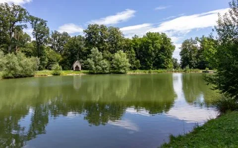 Trees and sky reflected in a still lake Stock Photos