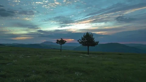 Trees in a clearing with a view of the mountains and sunset Stock Footage 284135322
