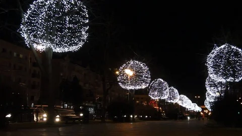 Trees decorated with glowing balls in the evening. Festive Christmas lighting. Stock Footage 78601191