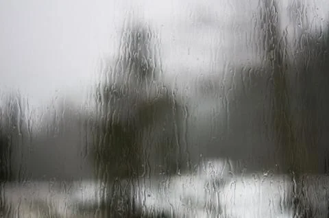 Trees distorted through raindrops on a window pane Foto stock