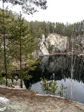 Trees growing on the shore of a flooded quarry called Talkov stone near the.. Stock Photos