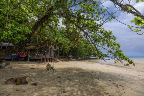 Trees on Kai Bae Beach under a blue sky with clouds on Koh Chang Island Stock Photos