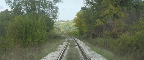 Trees by the railroad tracks 5.7K scope zooming out video Stock Footage 319239274