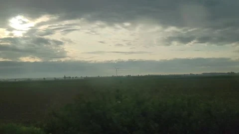 Trees in rural field under cloudy sky with sun rays 스톡 동영상 336818507