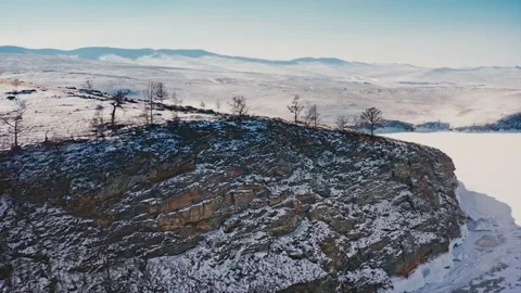 Trees on the slope of a snow-covered ice cliff on the shore of Lake Baikal. The Stock Footage 228826108