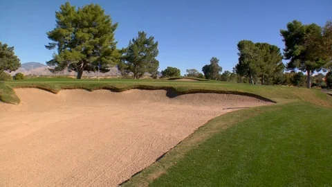 Trees surround putting green sand dune bunker Stock Footage 125278028
