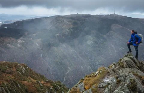 Trekker with a backpack standing on the top of mount Ulriken Stock Photos