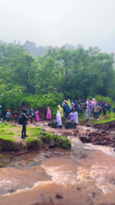 Trekker crossing a flooded river during monsoon season Видео 341797613