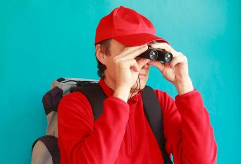 A trekker during an excursion looking through his binoculars Stock Photos